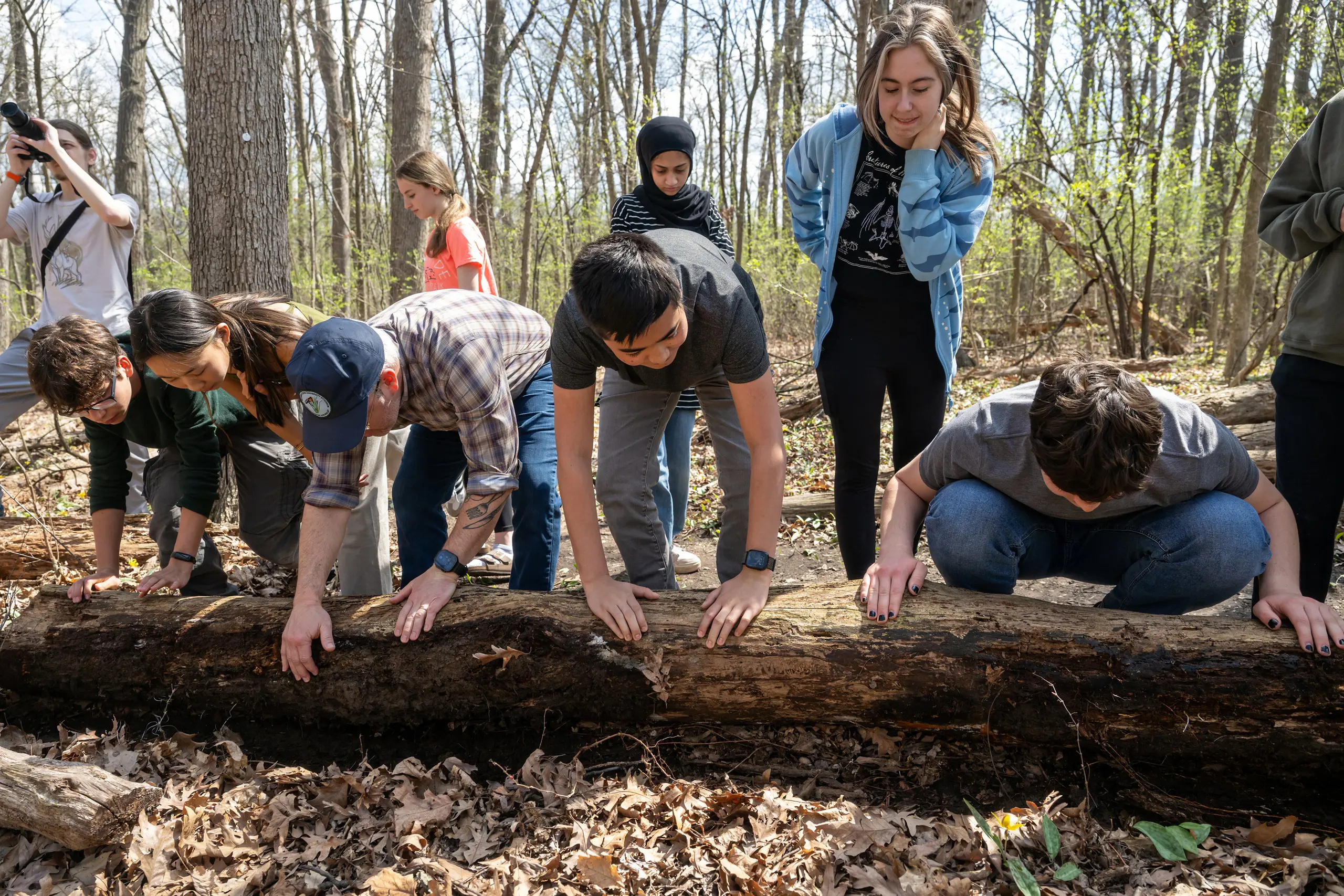 Students leaning on a log