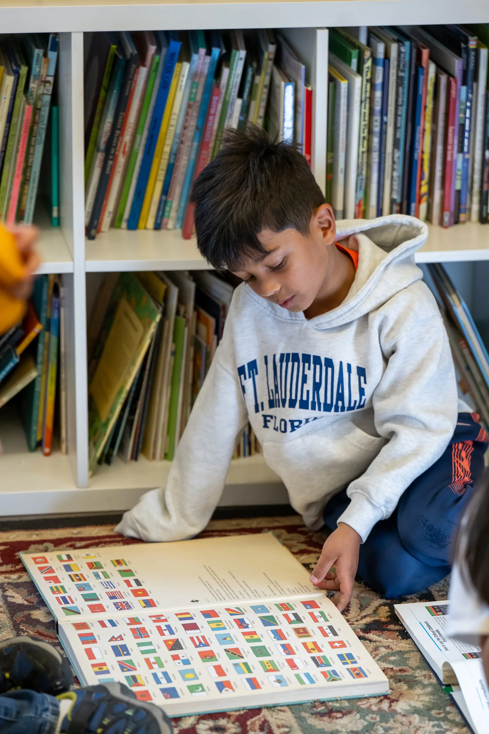 Student reading a book on the floor