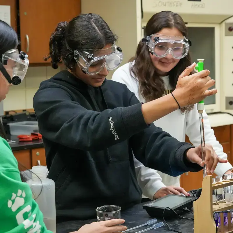 Three students working together on a science lab