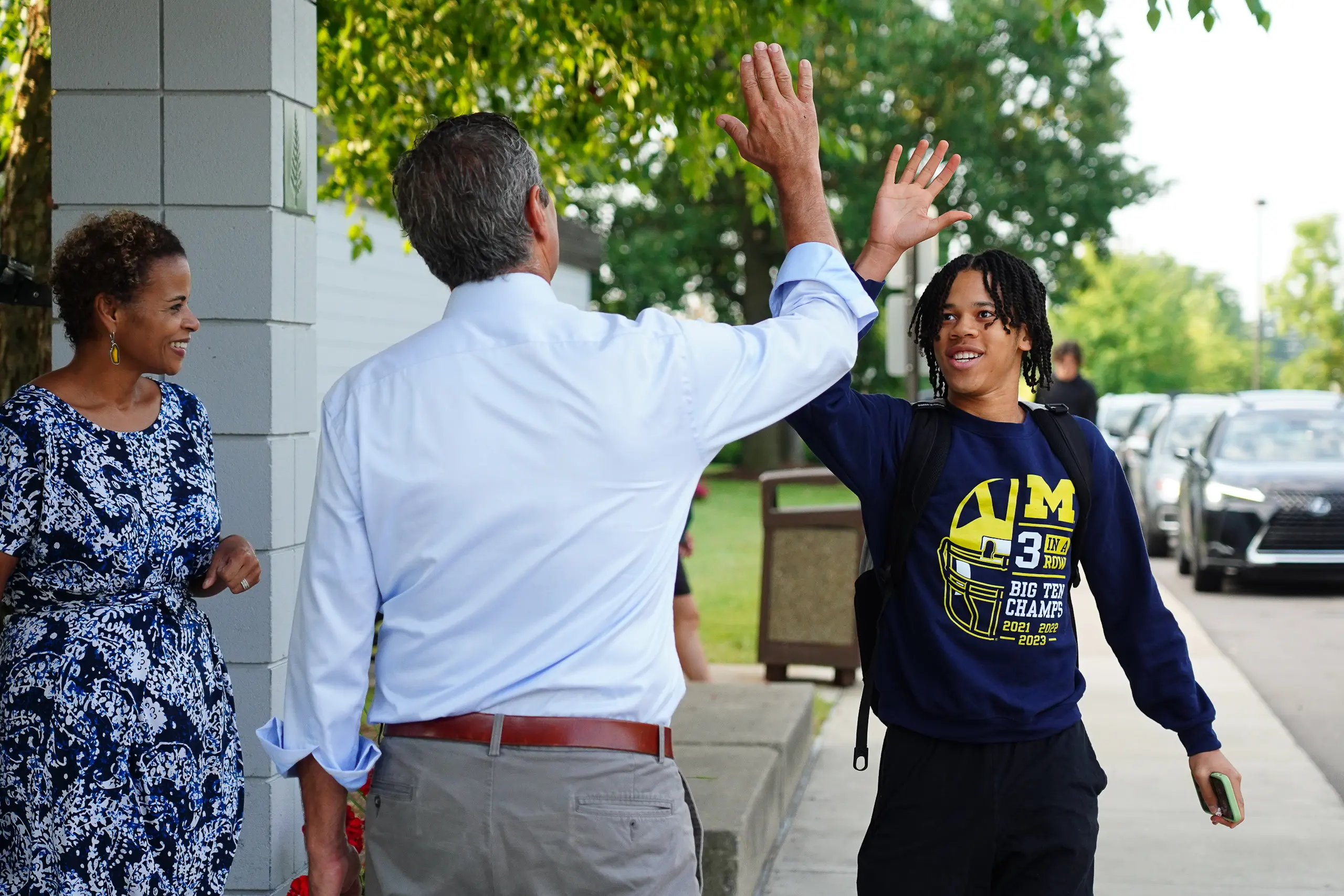 A student is greeted by the head of school on the way in